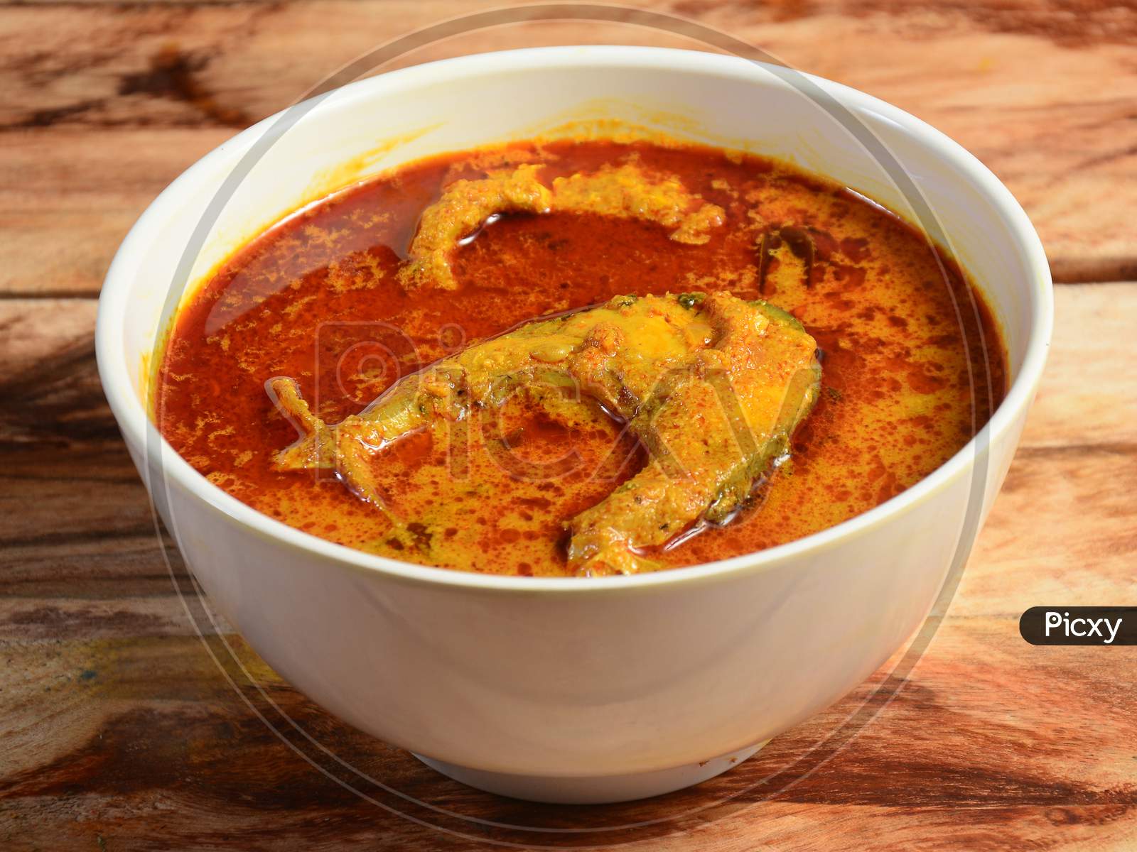 Spicy And Hot King Fish Curry, Kerala India. Barracuda Fish Curry With Green Chili, Coconut Milk And Mango Asian Cuisine.. Served Over A Rustic Wooden Background,Selective Focus