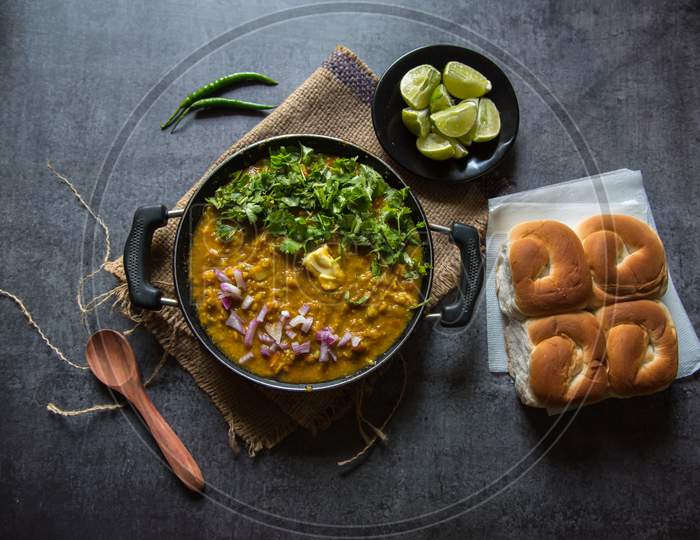 Indian snacks pav bhaji or bread masala curry in a black pan