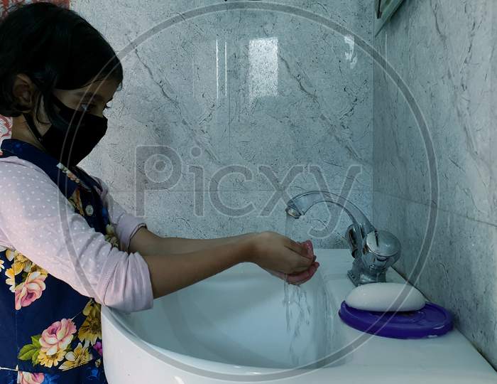 Masked Children Washing Hands During Coronavirus Pandemic. Hand Wash Mask Wearing And Using Sanitiser Are Recommended By World Health Organisation.