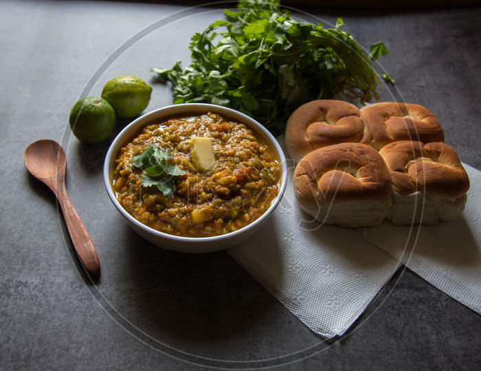 Spicy Indian dish pav bhaji or bread with masala curry along with food ingredients