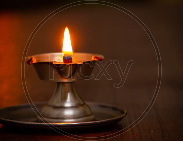 Close View Of Lit Diya Lamp. Lamp Made Out Of Silver Metal Lit During Festival.