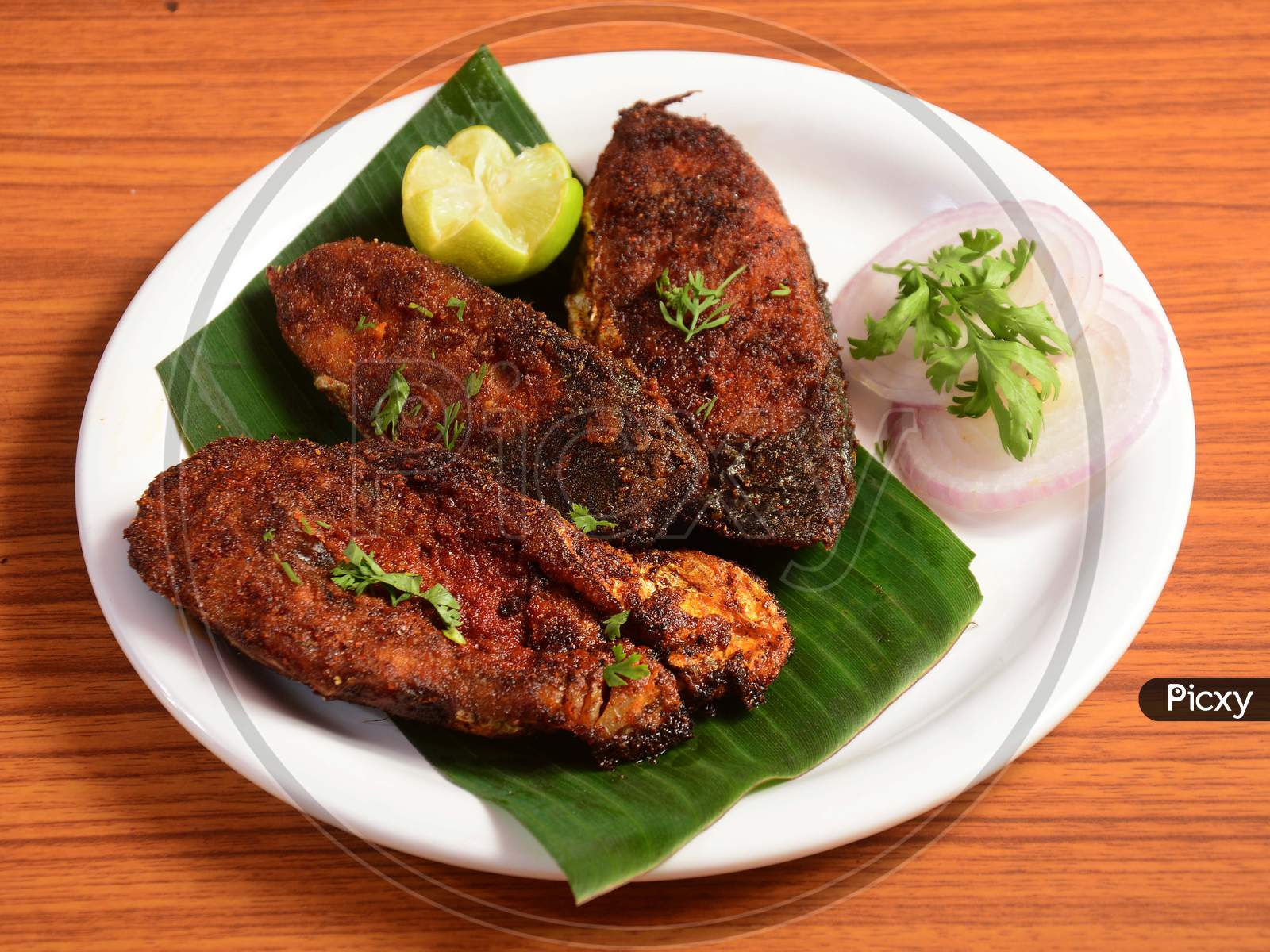 Delicious Crispy King Fish Fry Also Known As Indian Surmai, Served With Onion And Lemon Placed Over A Rustic Wooden Background,Selective Focus