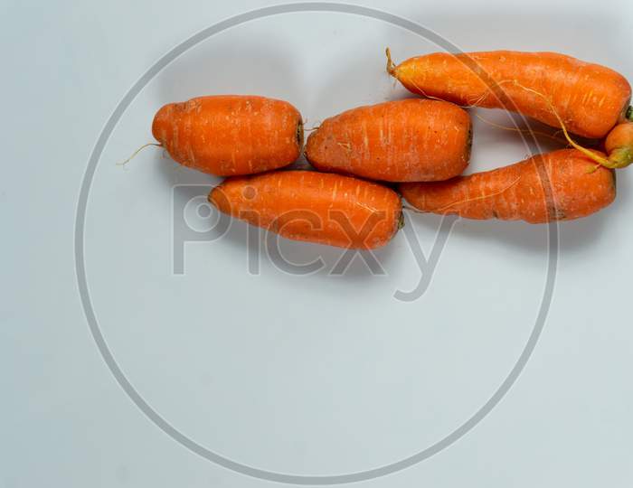 Fresh Raw Red Carrots Stacked Together On A White Background