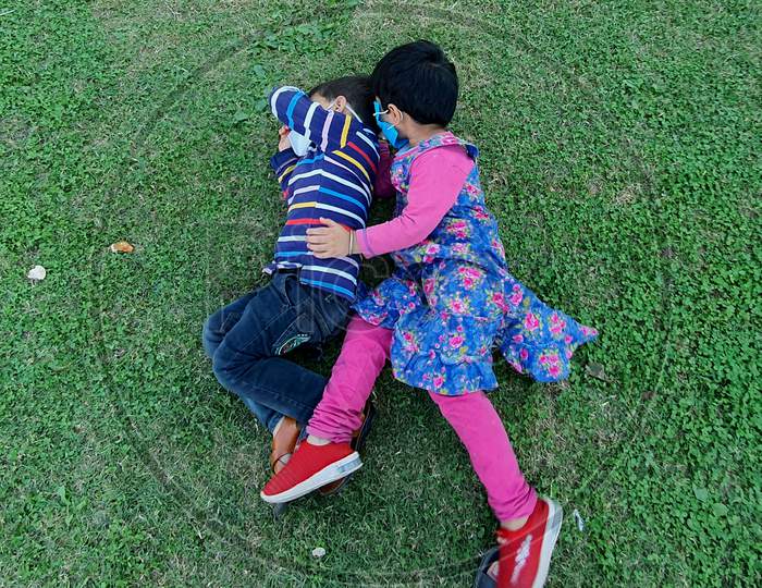 Masked Handsome Kids Are Playing Running Enjoying And Smiling At Home Park During Coronavirus Lockdown.