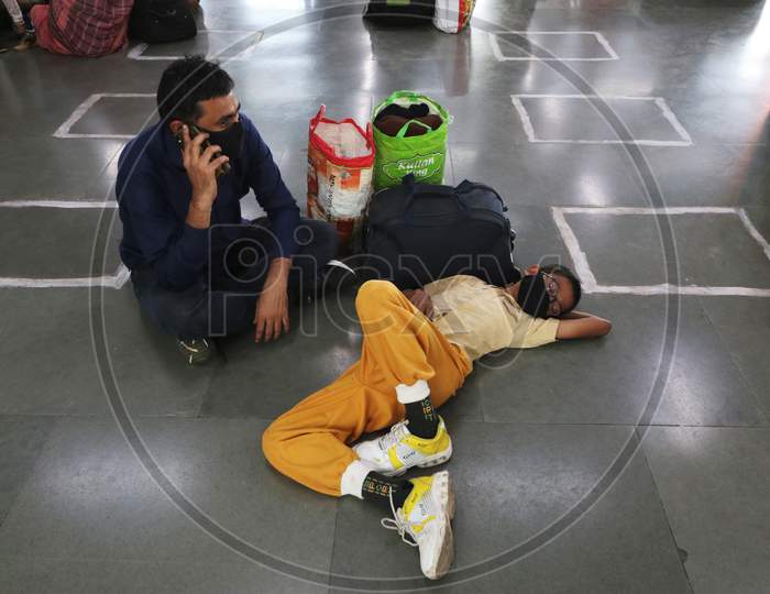 People wearing protective masks wait for a train at a railway station, amid the spread of the coronavirus disease (COVID-19), in Mumbai, India, November, 2020.