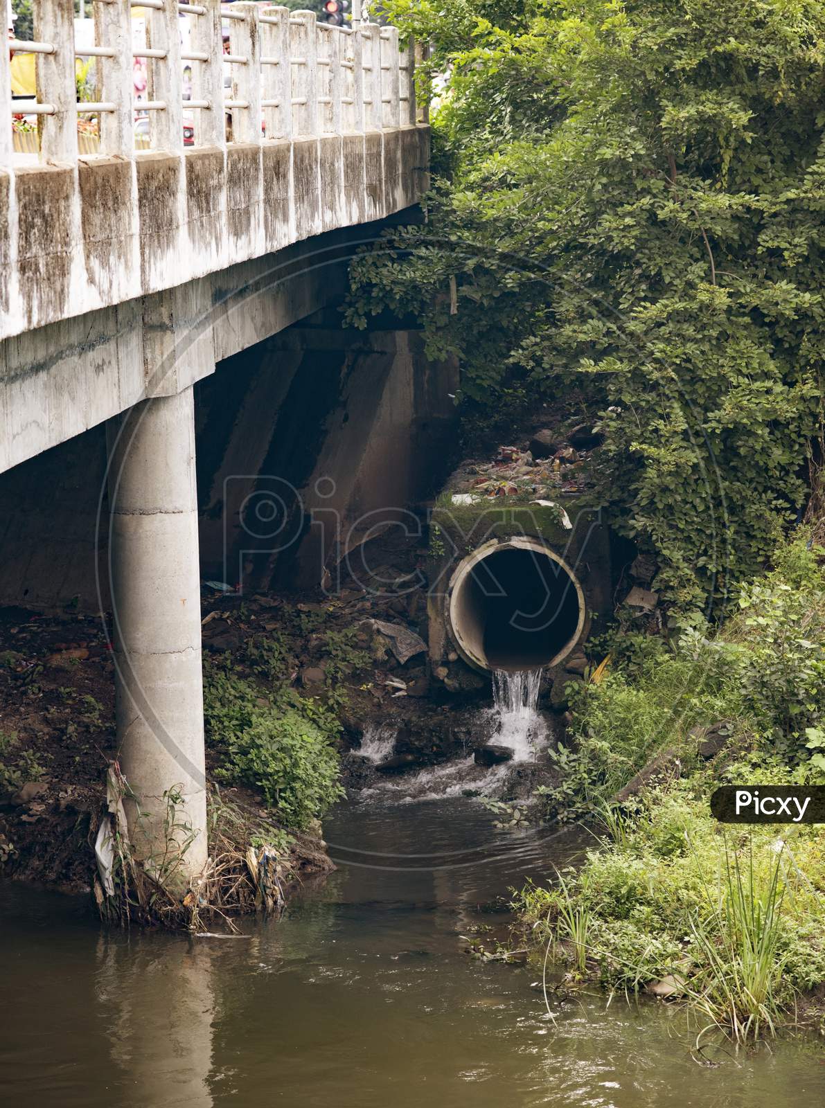 Water Flowing Out Of A Municipal Storm Drainage Into A Creek