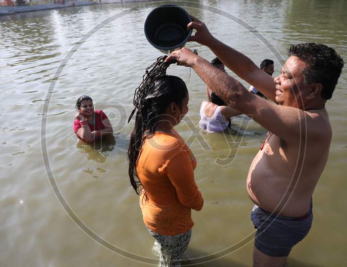 Hindu devotees take a holy dip in the pond during the annual farmer fair at Shama Chak Jhiri, some 22 km from Jammu,30,November,2020.