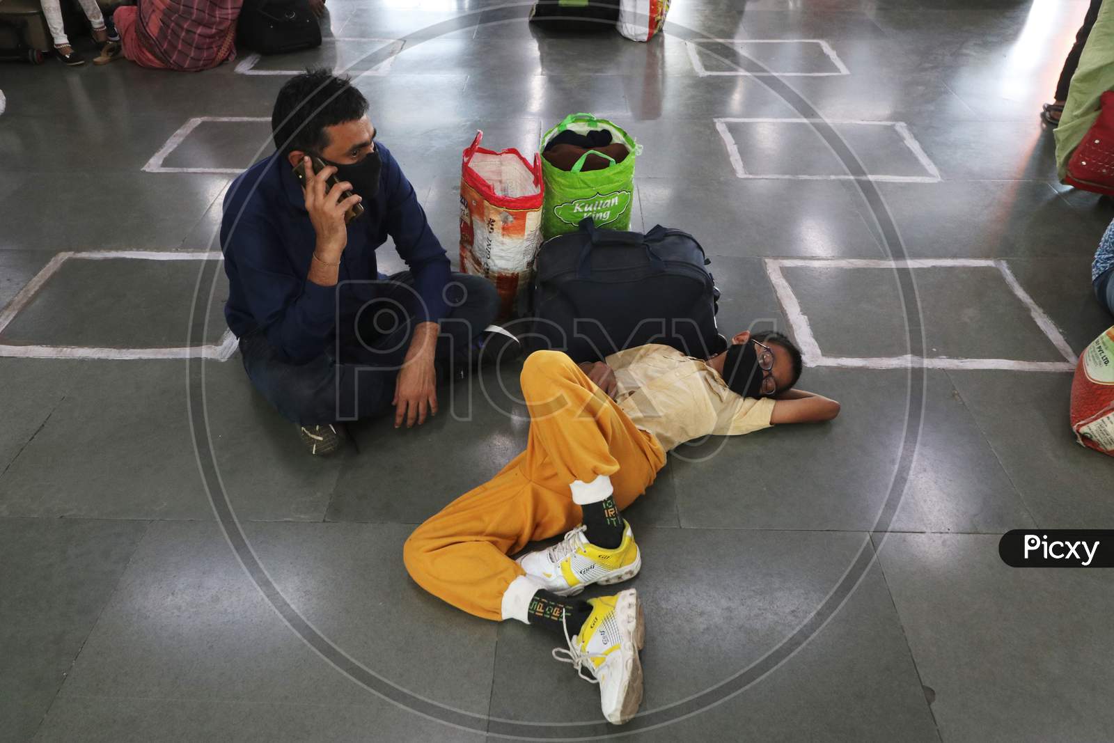 People wearing protective masks wait for a train at a railway station, amid the spread of the coronavirus disease (COVID-19), in Mumbai, India, November, 2020.