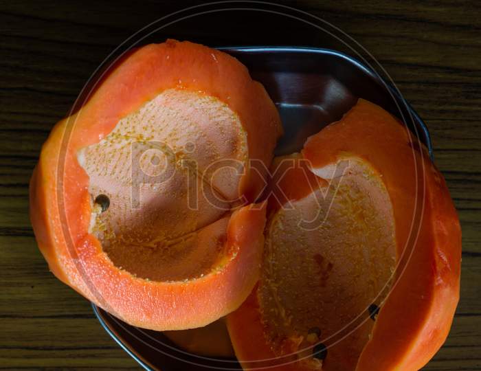 Fresh Papaya Cut Into Two Pieces Kept In A Plate