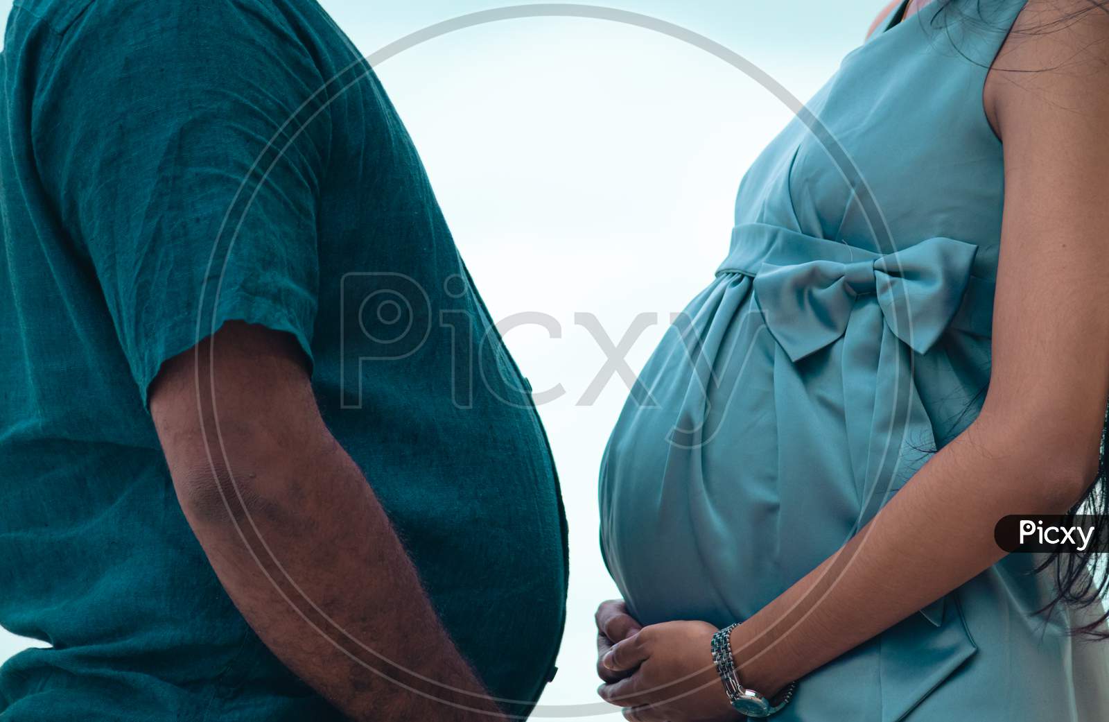 Pregnant Belly And A Beer Belly Against Each Other Together Close Up, Holding Bellies By Both Hands Side View, Couple Goals Concept.