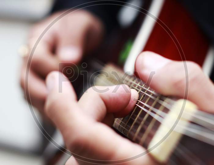 Hands Of Musician Playing Mandolin With Selective Focus On Front Fingers- Hands Of Musician Playing Guitar With Shallow Depth Of Field