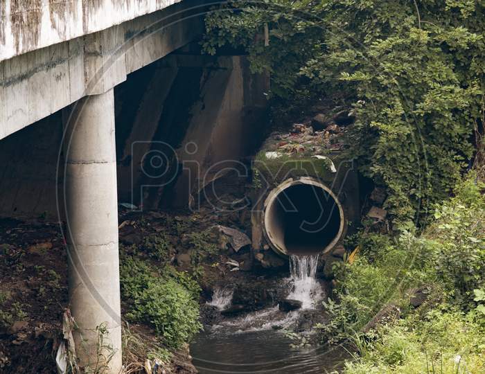 Water Flowing Out Of A Municipal Storm Drainage Into A Creek