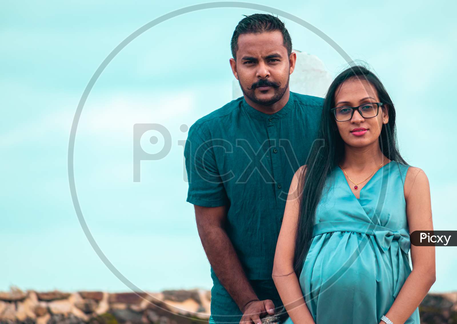 The Pregnant Young Lady And Her Handsome Husband Portrait, Under The Blue Skies Natural Lighting Conditions In Galle Fort, South Asian Young Couple.