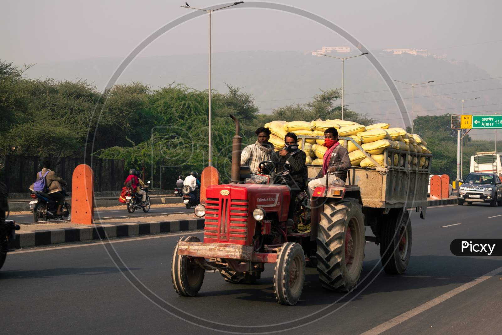 A tractor carrying heavy load or bags on national highway