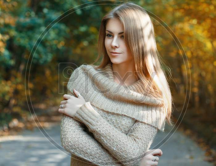 Beautiful Girl In A Sweater Standing In Autumn Park