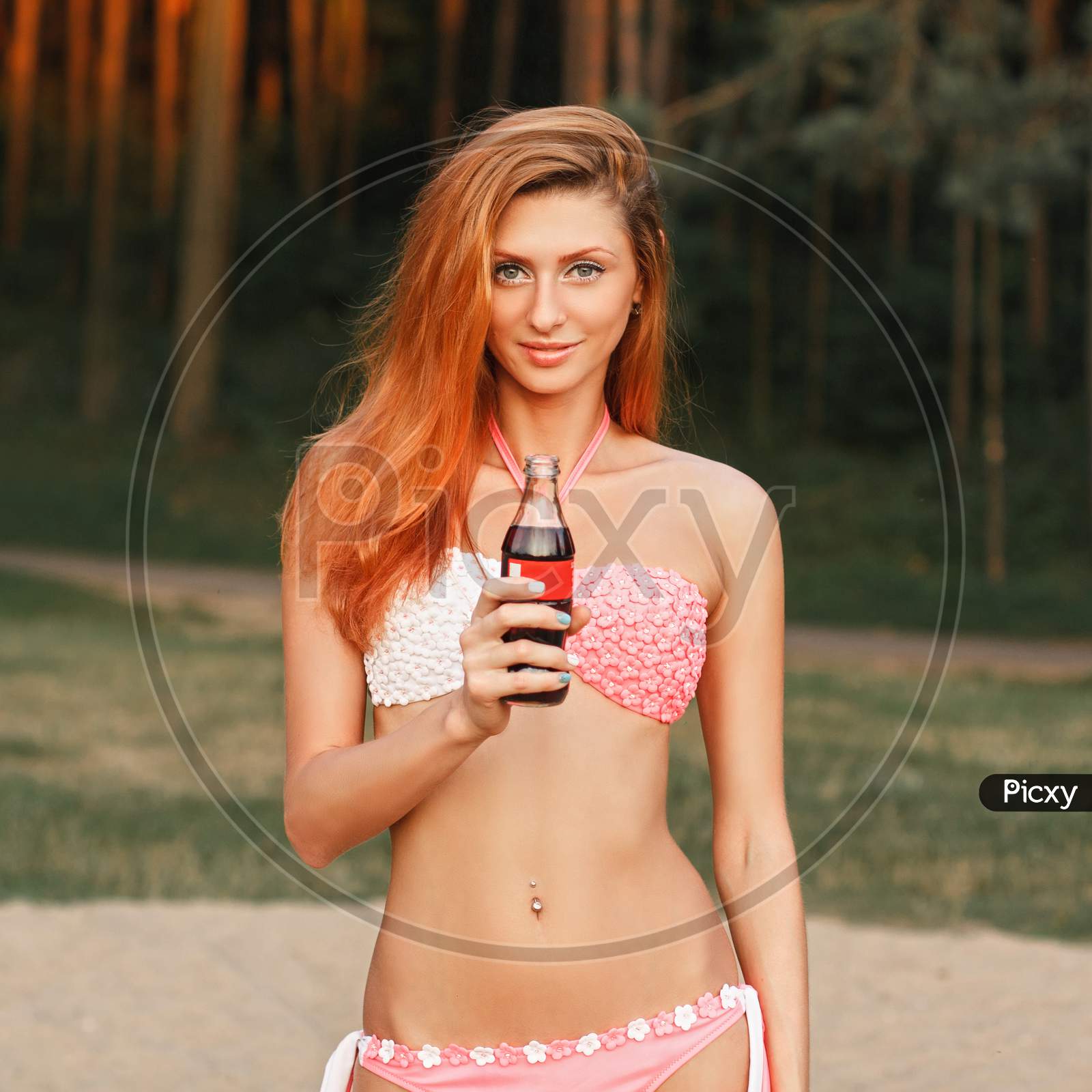 Beautiful Girl With Red Hair Holding A Bottle Of Drink