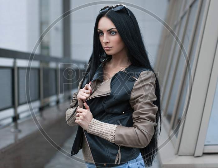 Girl In A Leather Jacket Standing Near The Building