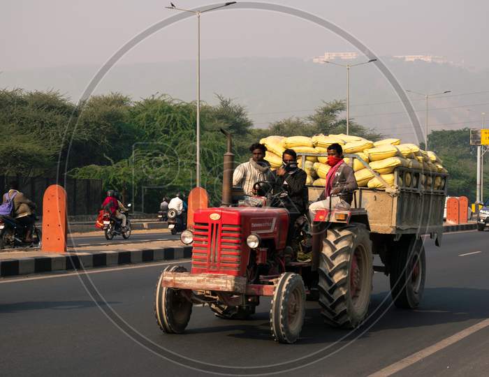 A tractor carrying heavy load or bags on national highway