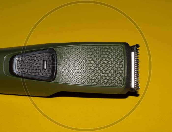 Hair Trimmer Isolated On The Yellow Background. Beard And Hair Clippers.