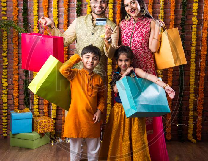 Happy Indian Family Showing Shopping Done For Diwali Or Raksha Bandhan Using Electronic Card