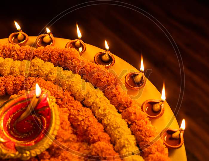 Happy Diwali - Clay Diya lamps lit during Dipavali, Hindu festival of lights celebration.