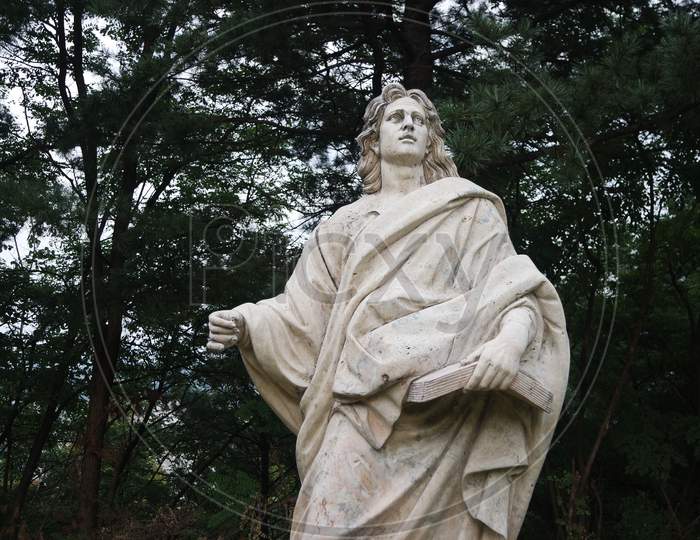 White Marble Statue Of Man In A Public Park