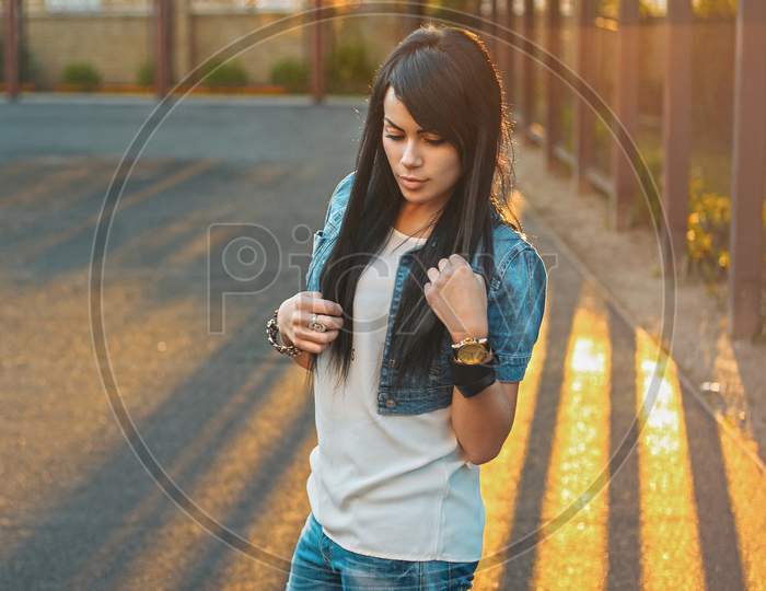 Beautiful Girl In A Denim Jacket In The Sunlight Sunset.