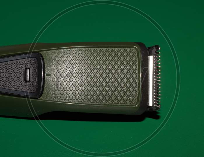 Hair Trimmer Isolated On The Green Background. Beard And Hair Clippers.