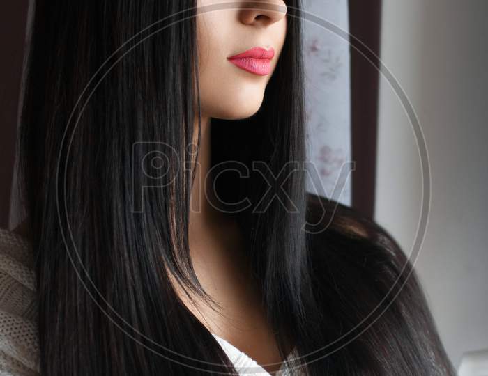 Beautiful Girl With Long Hair Stands By The Window
