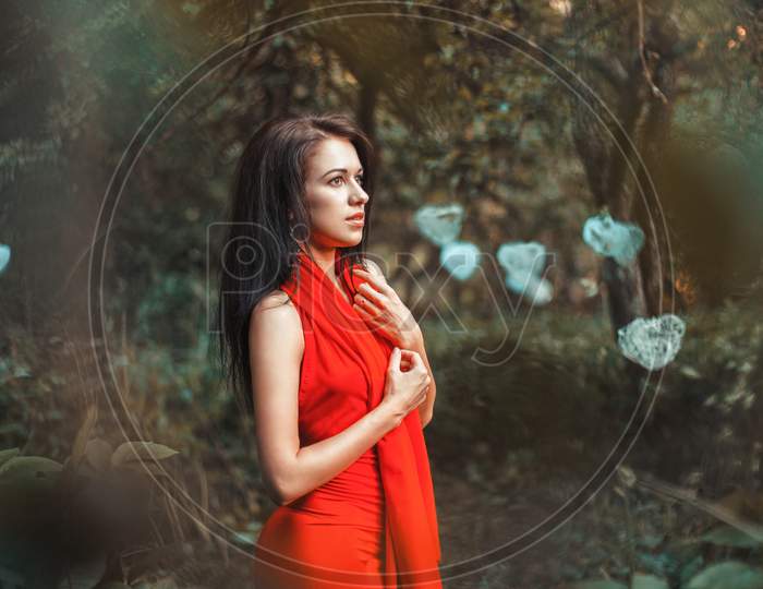 Fabulous Girl In A Red Dress Standing In The Garden With Hearts