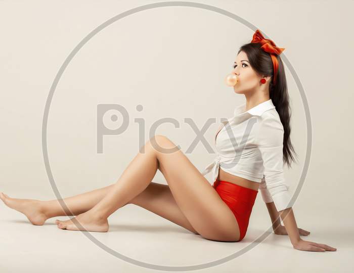 Pinup Girl  With Cud Sitting In Studio. Back To 1950S