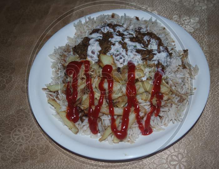 Delicious Traditional Dish Of Rice, Potato Fries And Cereals With Red Ketchup.