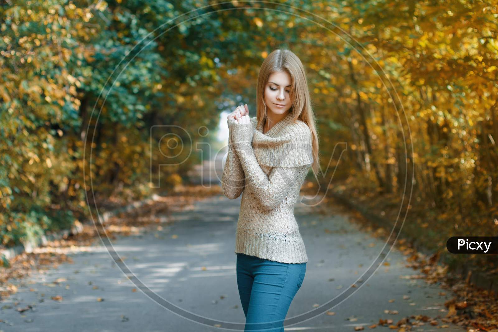 Cute Woman In A Jersey Standing In Autumn Park