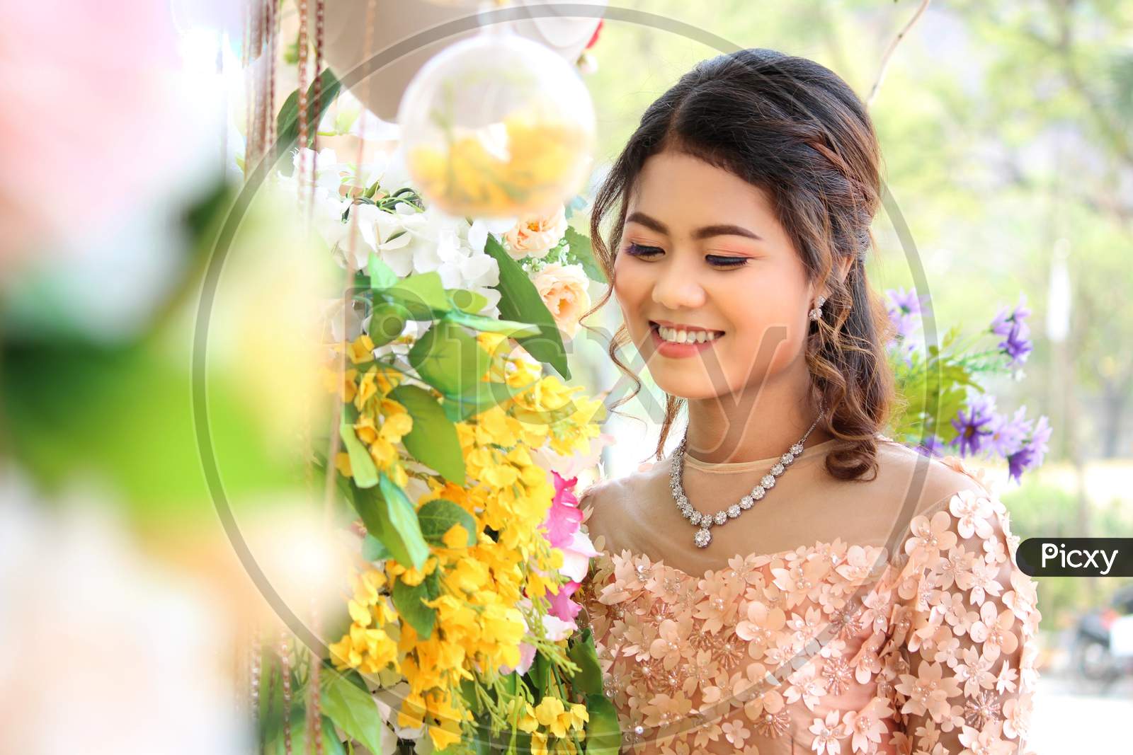 Myanmar Woman Smiling Beneath The Yellow Flowers