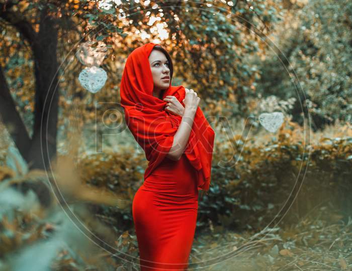 Beautiful Girl In A Red Dress Standing In The Garden With Hearts