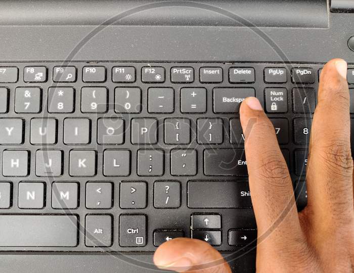 Finger Pressing A Backspace Button On The Laptop Keyboard. Selective Focus