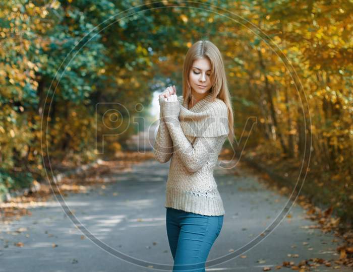 Cute Woman In A Jersey Standing In Autumn Park