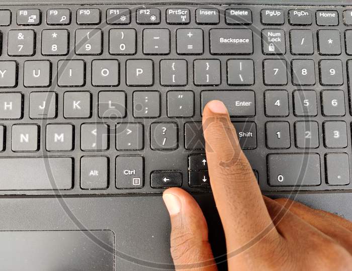 Finger Pressing A Enter Button On The Laptop Keyboard. Selective Focus