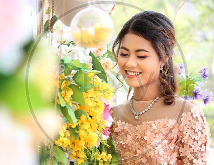 Myanmar Woman Smiling Beneath The Yellow Flowers