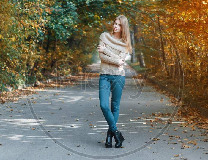 Pretty Girl In A Pullover Standing In Autumn Park