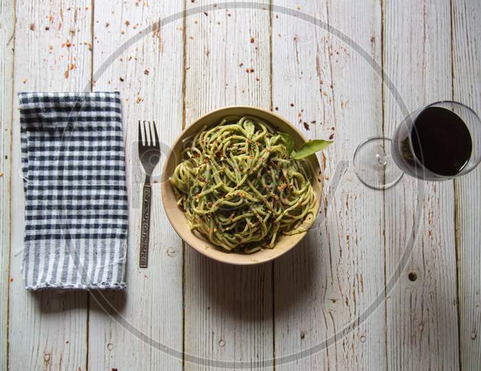 Italian delicacy pasta in pesto sauce and drink on a background