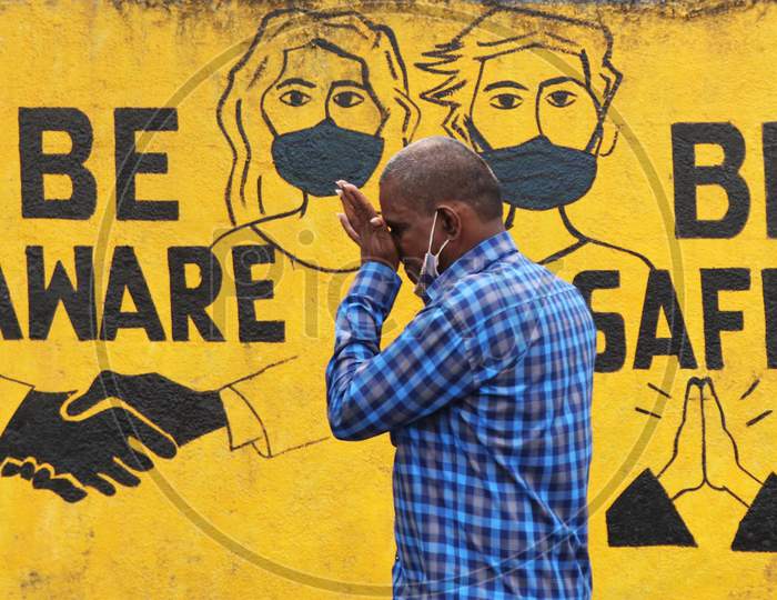 A man walks past a graffiti amid the spread of the coronavirus disease (COVID-19) in Mumbai, India, November, 2020.