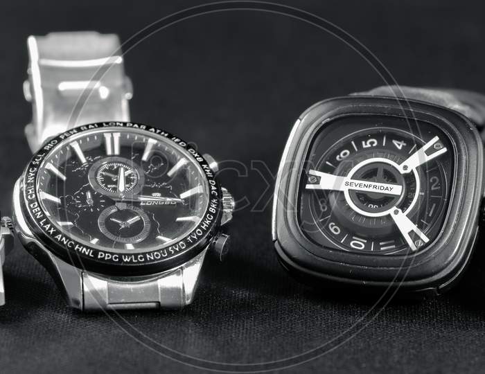 Four Watches Lined In A Dark Grey Surface.