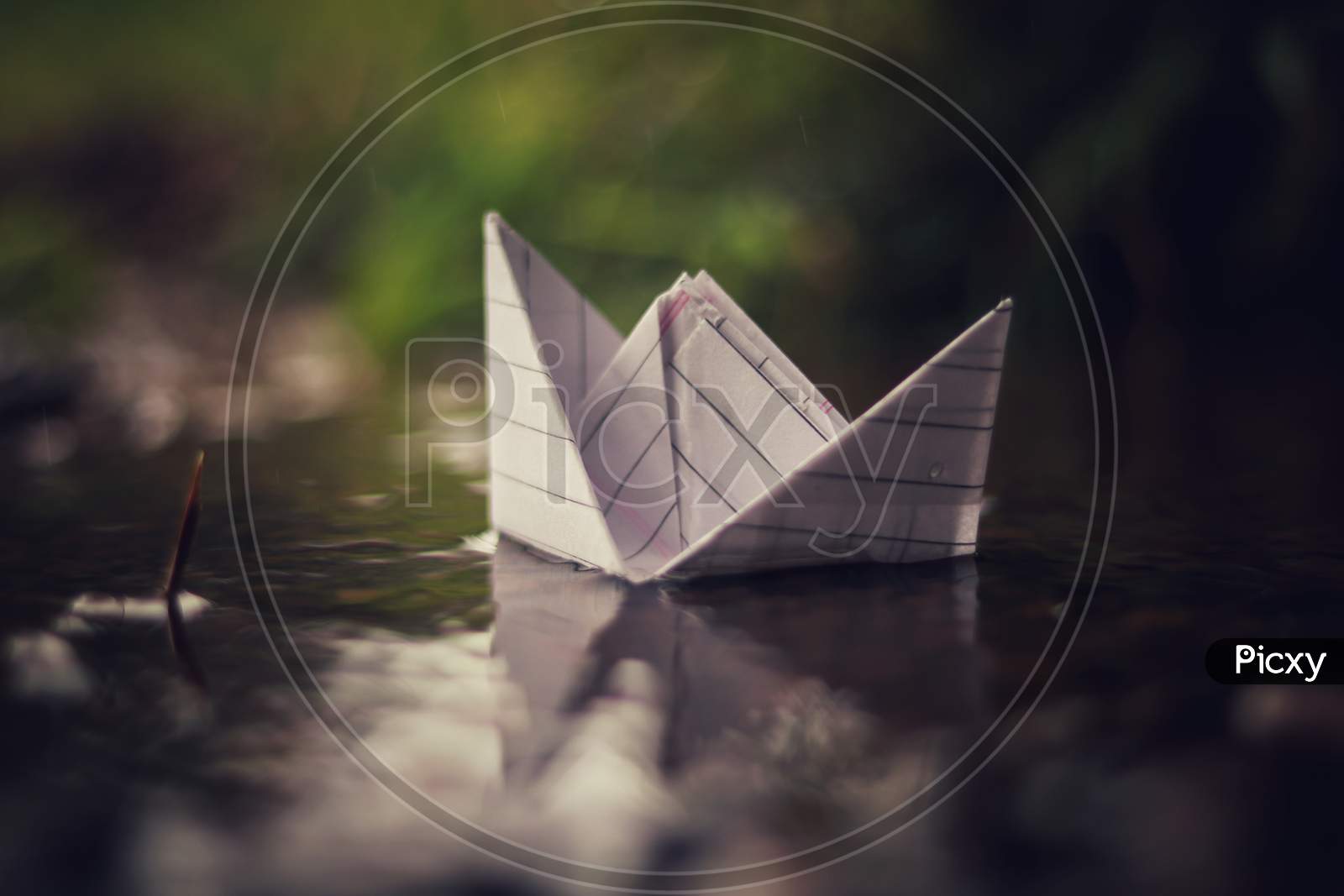 A paper boat floating on rainy water in rainy season