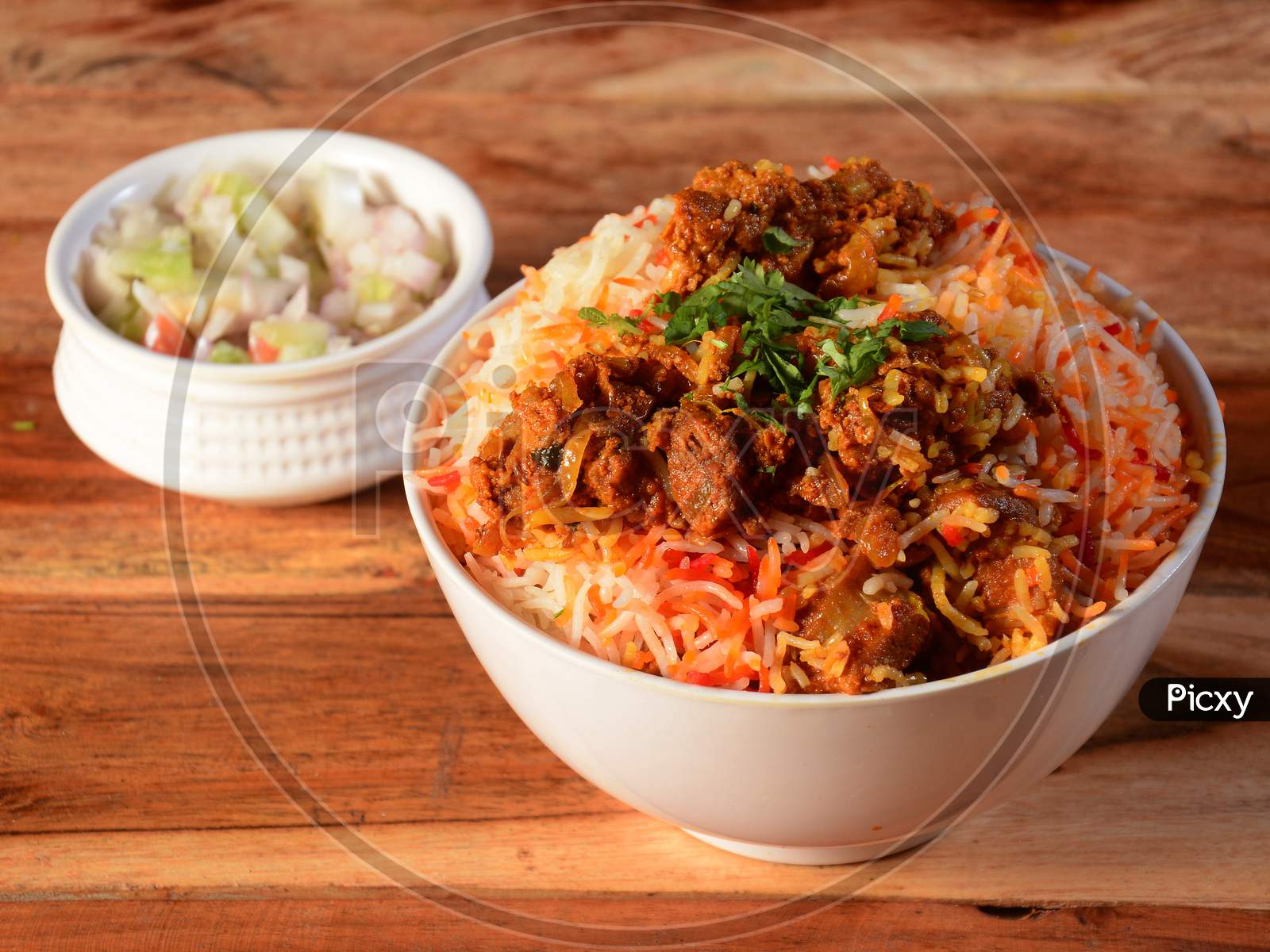 Beef Biryani Prepared In Basmati Rice Served With Onion Over Rustic Wooden Background, Selective Focus