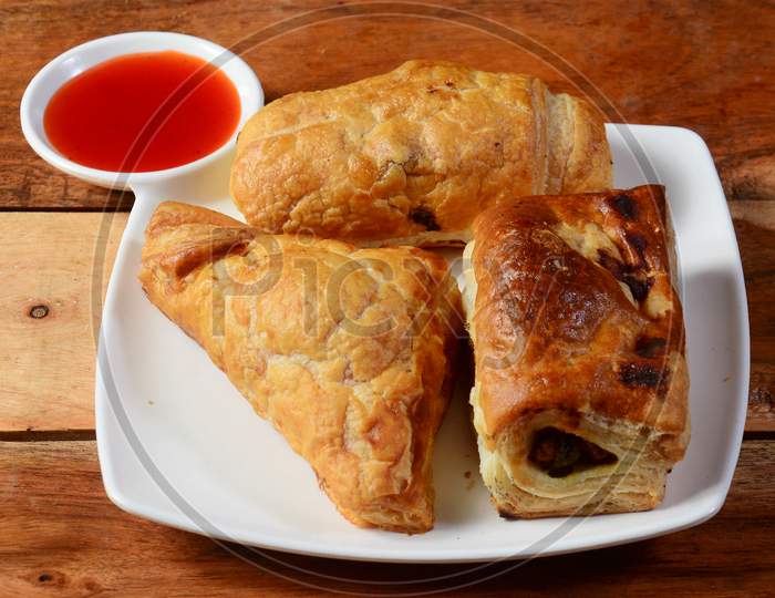 Stuffed Vegetable Puff,Chicken Puff And Egg Puff. Famous Indian Bakery Snack, Served With Tomato Ketchup, Selective Focus