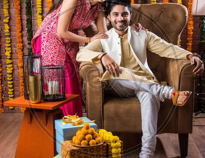 Indian Young Couple Celebrating Birthday, Anniversary Or Diwali Festival With Boondi Laddoo & Gifts