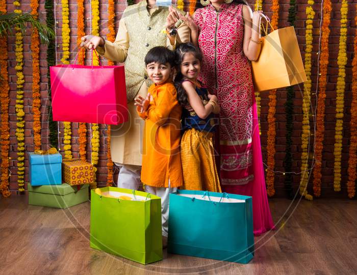 Happy Indian Family Showing Shopping Done For Diwali Or Raksha Bandhan Using Electronic Card