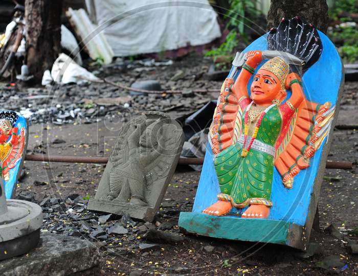 Painted Stone Sculpture Of Goddess Saptashrungi Lying Against A Tree