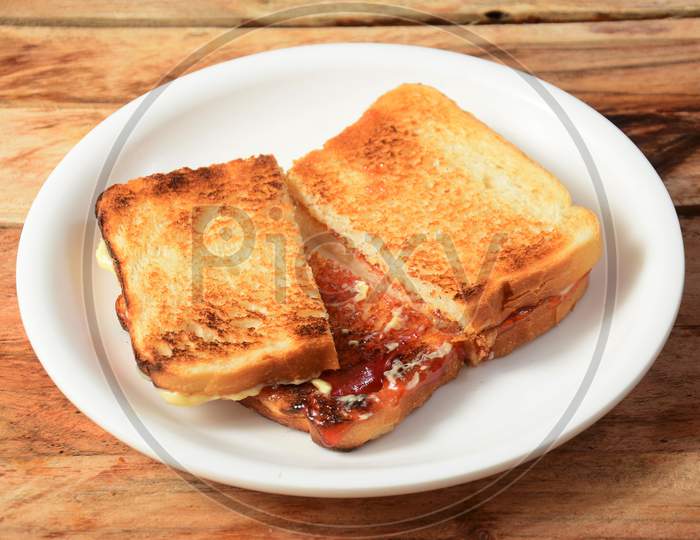 Two Slices Toast Bread With Butter And Jam On White Plate, Selective Focus